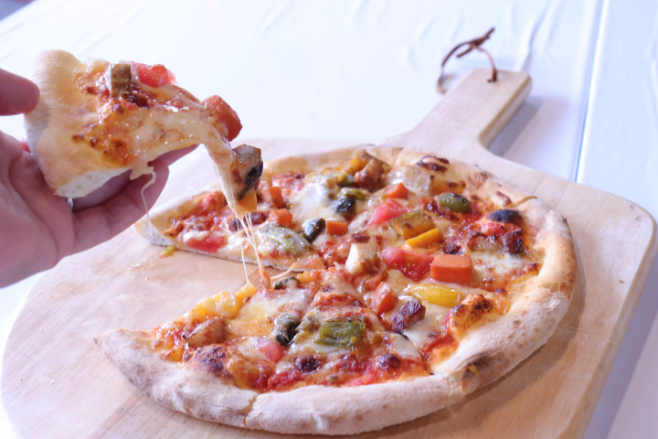 ピザを手に取りチーズが伸びる様子